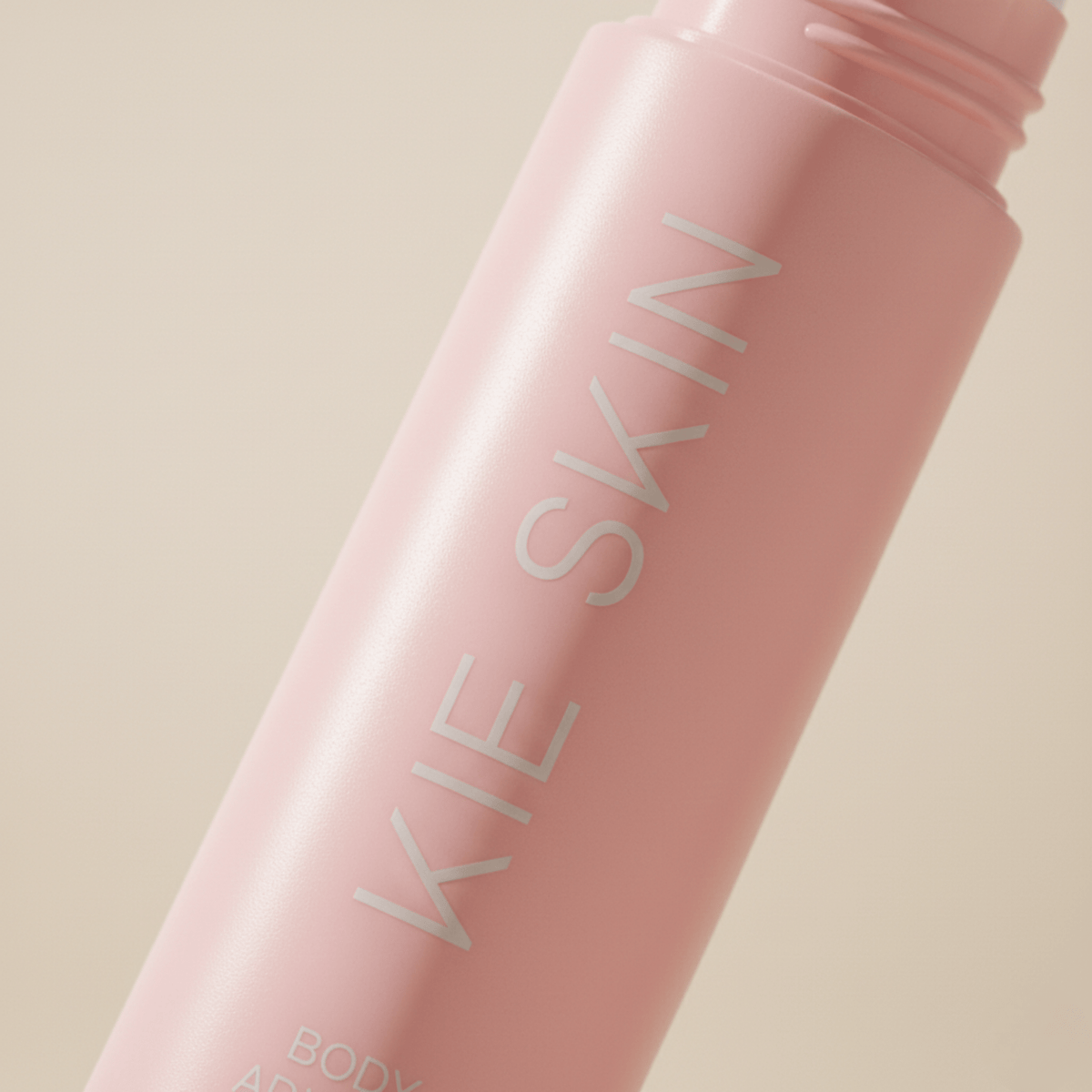 Close-up of the Kie Skin logo on the pink Body Adhesive roll-on bottle