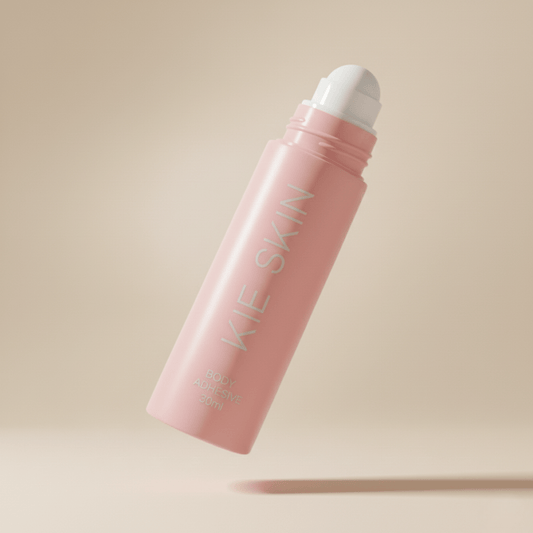 Kie Skin Body Adhesive pink 30ml roll-on bottle with cap off, showing the rollerball applicator