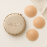 Kie Skin travel pouch beside three nude silicone nipple covers on a cream background