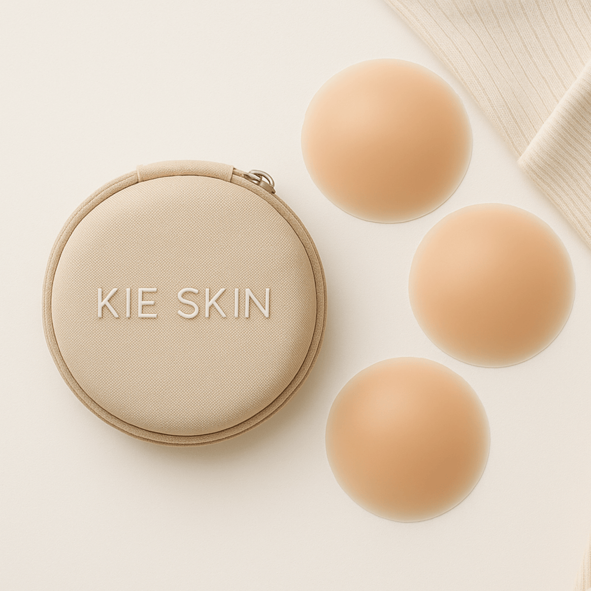 Kie Skin travel pouch beside three nude silicone nipple covers on a cream background