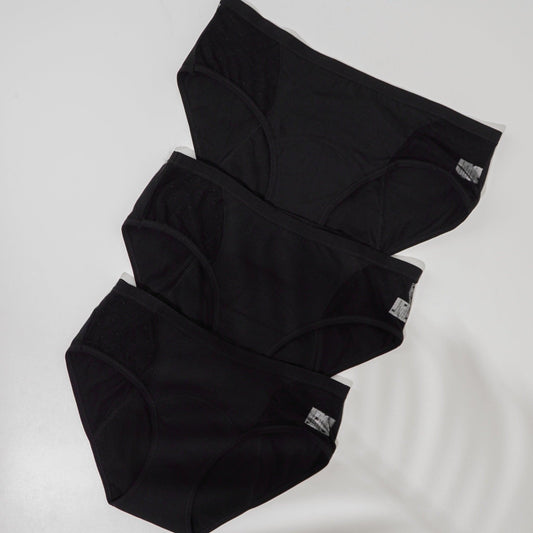 Three pairs of Kie Skin black leak-proof period underwear laid flat, showing the built-in absorbent liner
