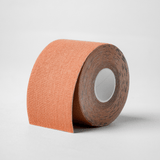 Roll of Kie Skin Premium Body Tape in tan cotton fabric on a white background